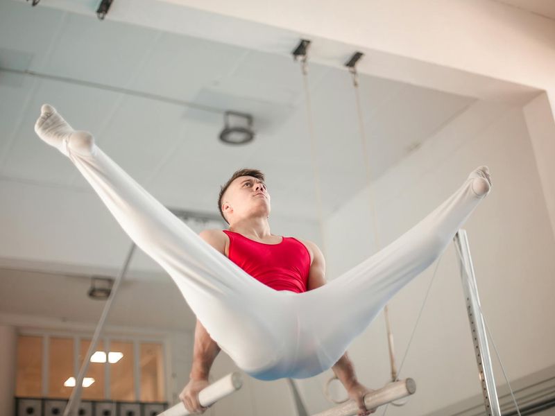 Man performing a controlled bodyweight exercise in a minimalist gym setting.